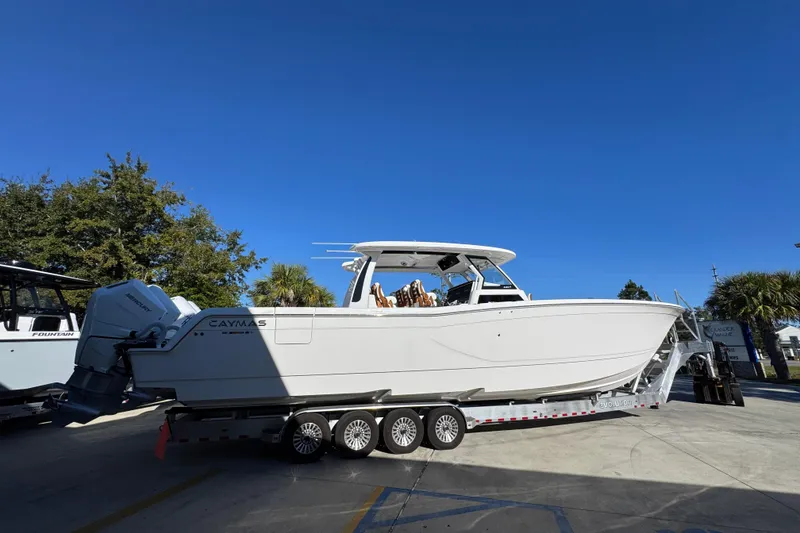 Slide: The Image of 2026 Caymas 44 CT boat on trailer under clear blue sky. - 9
