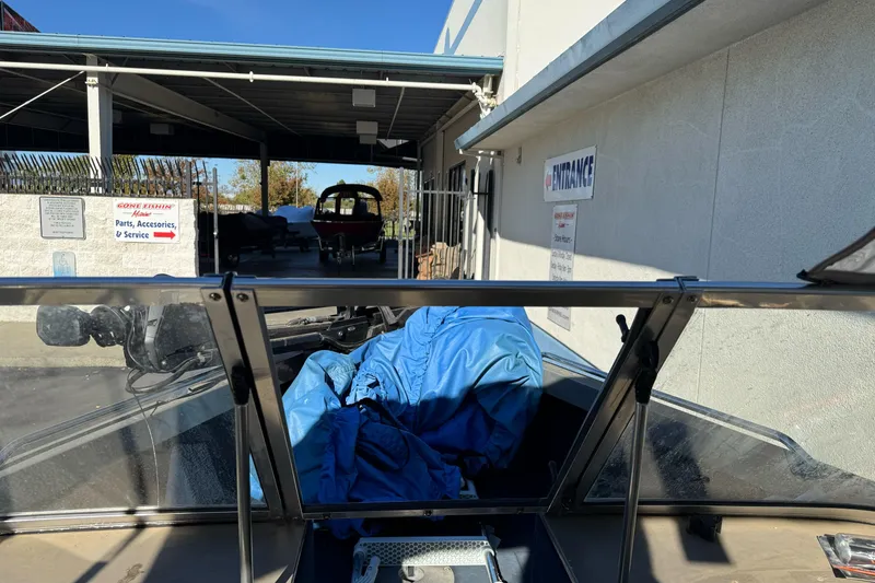 Slide: The Image of 2001 Lund 1700 Pro Sport boat at service center entrance with blue cover. - 10