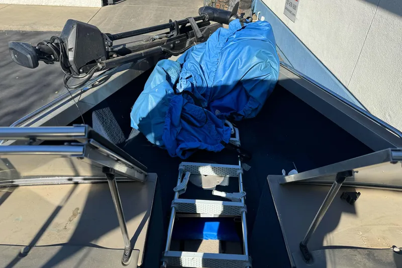 Slide: The Image of 2001 Lund 1700 Pro Sport boat interior with blue tarp and trolling motor. - 12