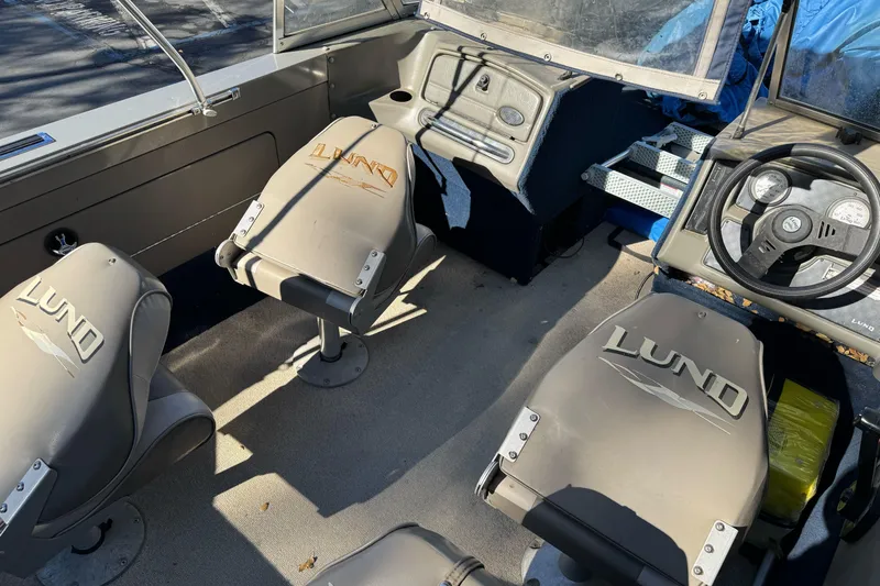 Slide: The Image of Interior of a 2001 Lund 1700 Pro Sport boat with branded seats and steering wheel. - 14