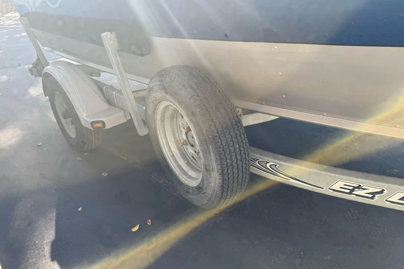 Slide: The Image of Trailer of a 2001 Lund 1700 Pro Sport boat with visible tire and sunlight. - 5