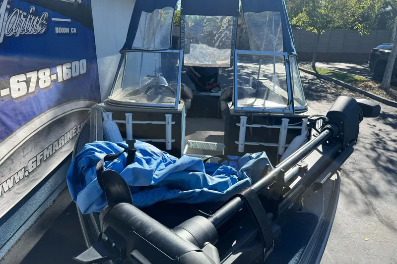 Slide: The Image of 2001 Lund 1700 Pro Sport boat with blue cover and motor, parked outdoors. - 6