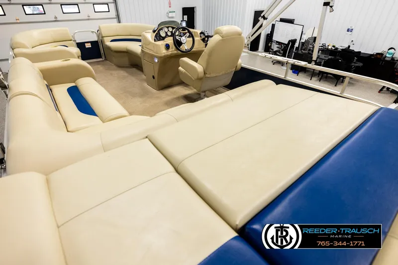 Slide: The Image of 2015 Lowe SS 210 pontoon boat interior with beige and blue seating, steering console visible. - 11