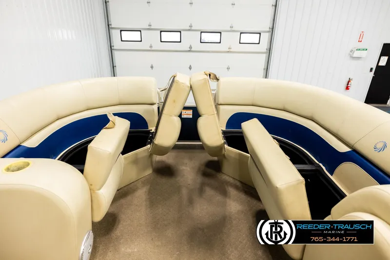Slide: The Image of 2015 Lowe SS 210 boat interior with beige and blue seating in a garage. - 19
