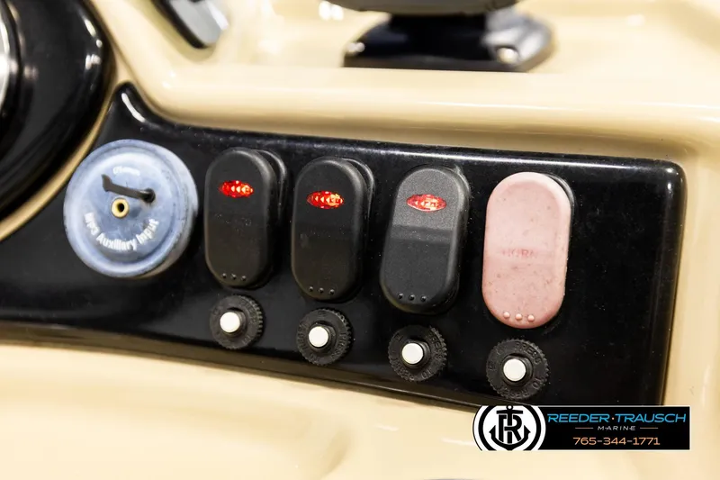 Slide: The Image of Control panel of a 2015 Lowe SS 210 boat with switches and auxiliary input. - 30