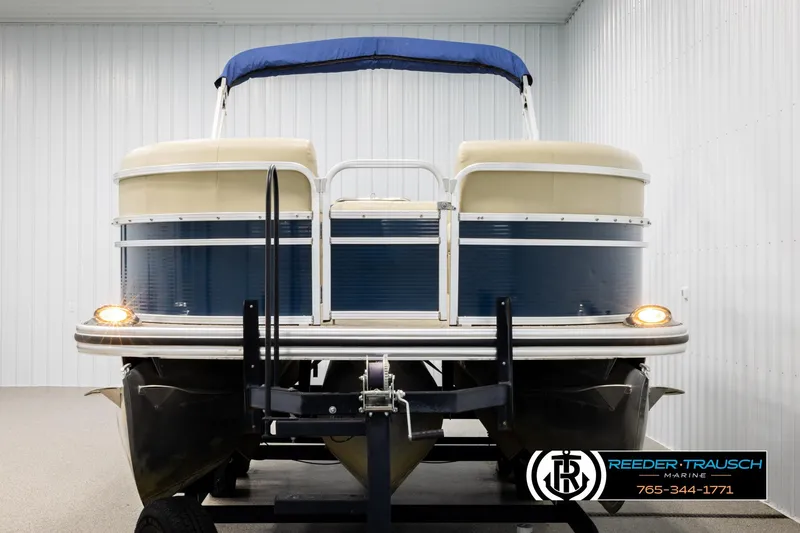 Slide: The Image of 2015 Lowe SS 210 pontoon boat with blue canopy in indoor storage. - 8
