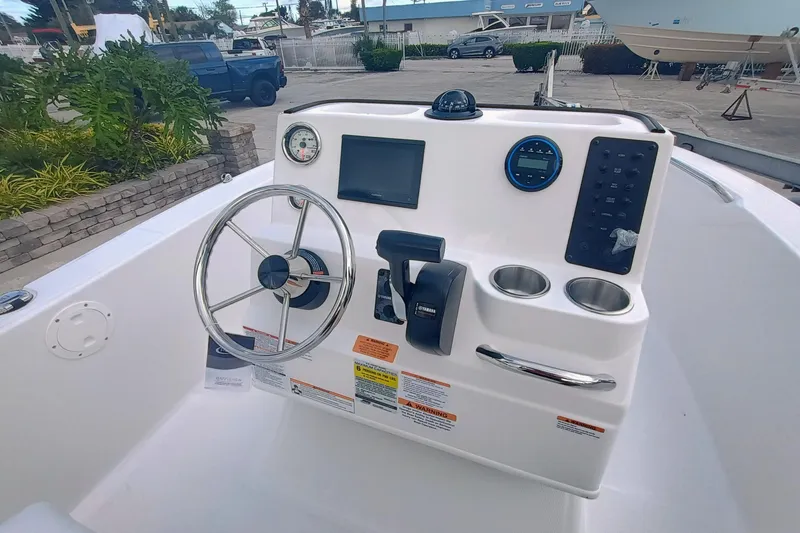 Slide: The Image of 2026 Robalo R160 Center Console boat dashboard with steering wheel and controls. - 12