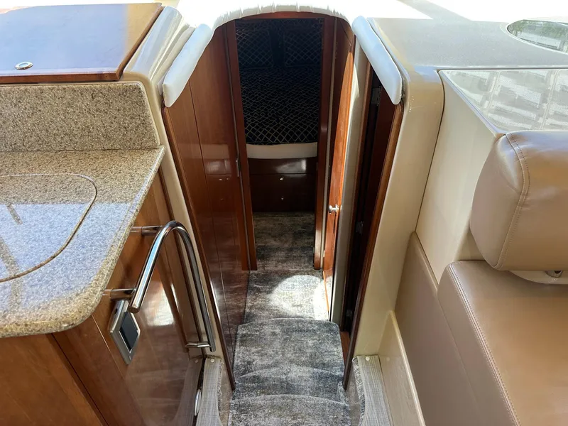 Slide: The Image of Interior view of a 2007 Meridian 411 Sedan yacht, featuring a carpeted stairway and wooden cabinetry. - 17
