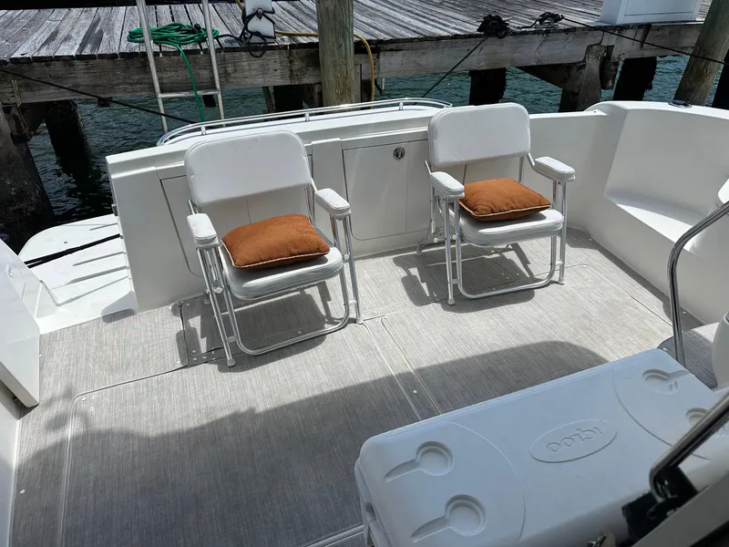 Slide: The Image of 2007 Meridian 411 Sedan yacht deck with chairs and cushions, docked by wooden pier. - 21