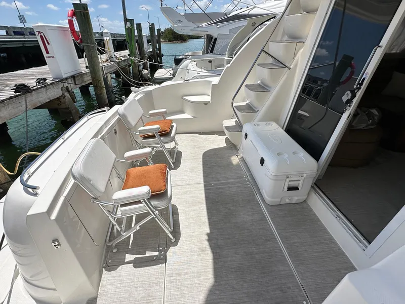Slide: The Image of 2007 Meridian 411 Sedan yacht deck with chairs and cooler, docked by the water. - 22