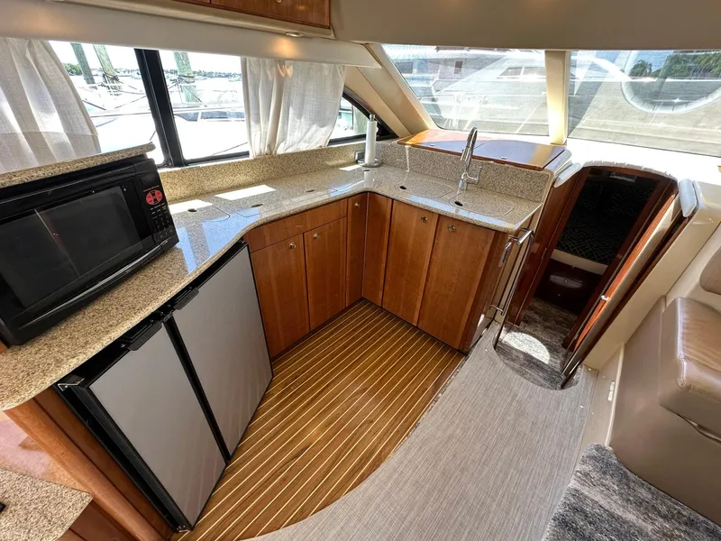 Slide: The Image of Interior of 2007 Meridian 411 Sedan yacht kitchen with wood cabinets and modern appliances. - 28