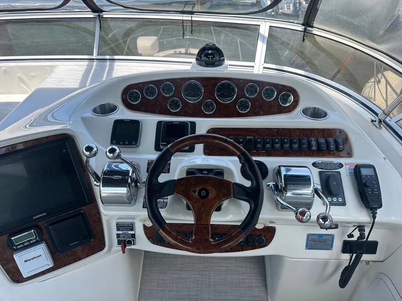 Slide: The Image of 2007 Meridian 411 Sedan helm with wood accents, steering wheel, and navigation controls. - 8