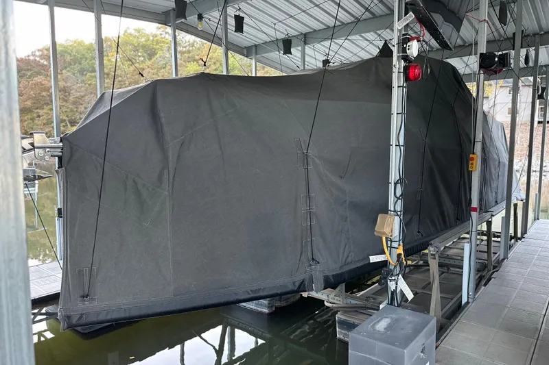 Slide: The Image of Covered 2025 Navan S-30 boat on a lift in a sheltered dock area. - 22