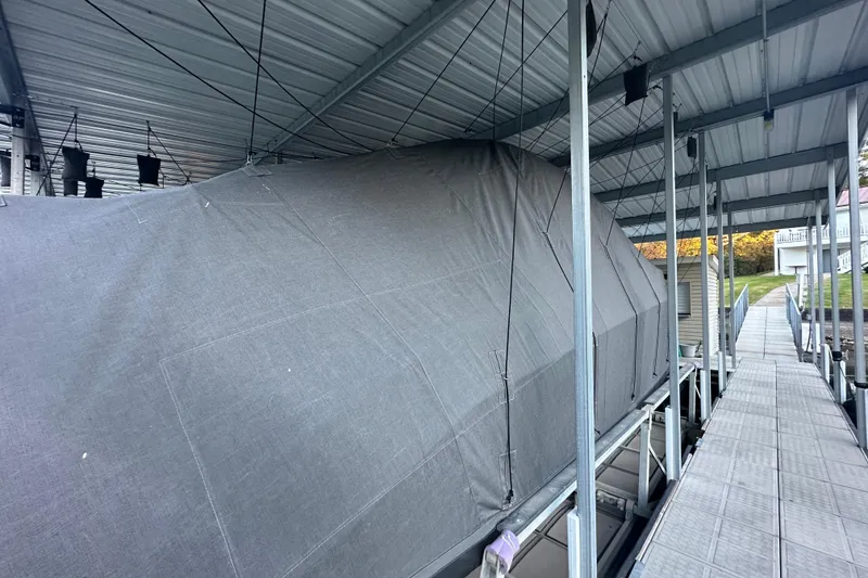 Slide: The Image of Covered Navan S-30 boat in dock, 2025 model, under metal roof. - 45