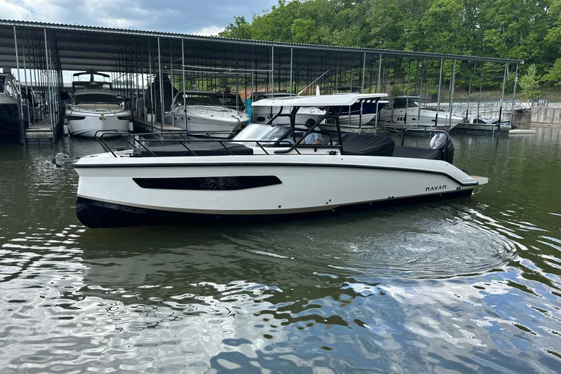 Slide: The Image of Modern 2025 Navan S-30 boat docked in a marina with surrounding greenery. - 54