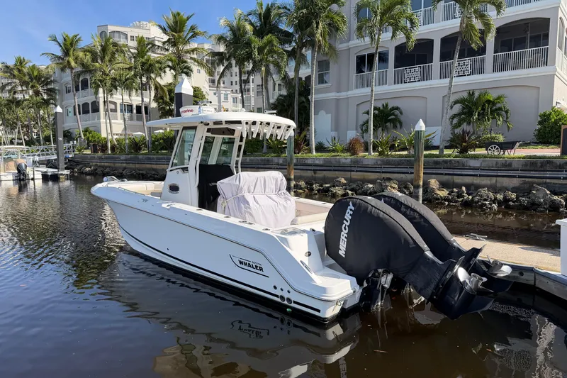 Slide: The Image of 2018 Boston Whaler 250 Outrage boat docked near luxury waterfront residences. - 1