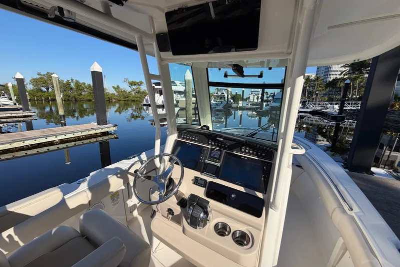 Slide: The Image of 2018 Boston Whaler 250 Outrage boat cockpit with steering wheel and control panel. - 13