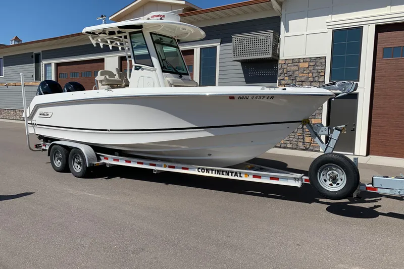 Slide: The Image of 2018 Boston Whaler 250 Outrage boat on trailer, parked outside a building. - 2