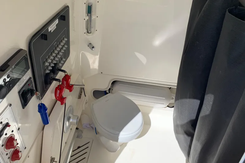 Slide: The Image of Interior of 2018 Boston Whaler 250 Outrage boat with control panel and marine toilet. - 8