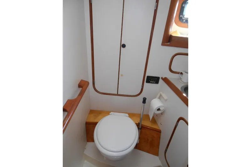 Slide: The Image of Compact bathroom in 1989 Norseman 447 yacht with toilet, sink, and wooden accents. - 12