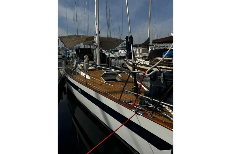 Slide: The Image of Sailboat Norseman 447, 1989 model, docked at marina with wooden deck and rigging. - 19