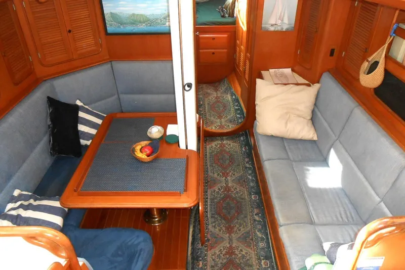 Slide: The Image of Cozy interior of 1989 Norseman 447 yacht with blue seating and wooden accents. - 2