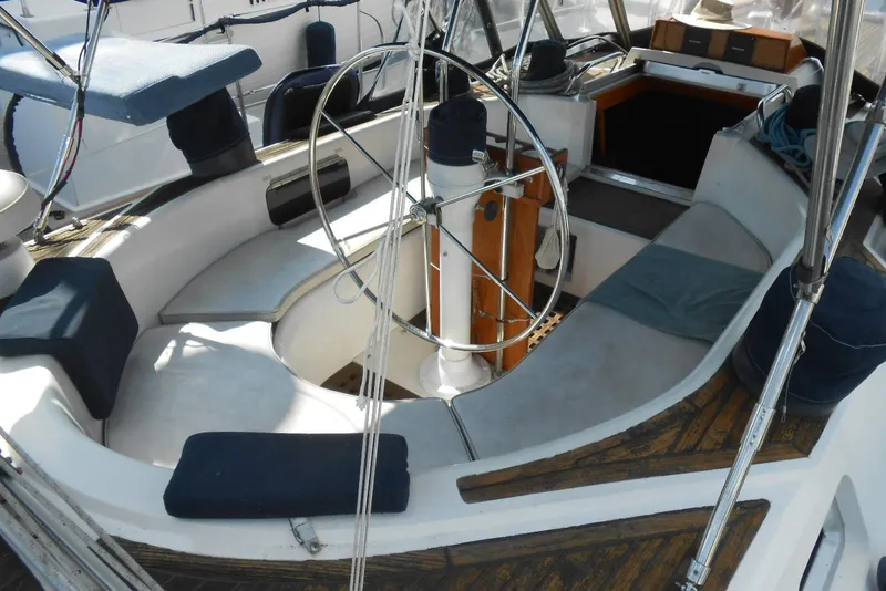Slide: The Image of 1989 Norseman 447 sailboat cockpit with steering wheel and seating area. - 22