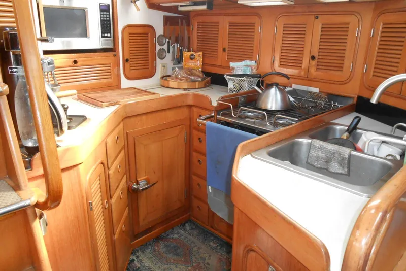 Slide: The Image of 1989 Norseman 447 yacht kitchen with wooden cabinets, stove, and sink. - 5
