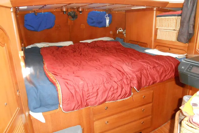 Slide: The Image of Cozy cabin interior of 1989 Norseman 447 with red bedding and wooden storage. - 8