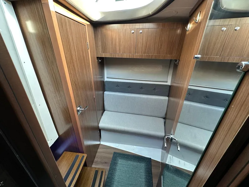 Slide: The Image of Interior of 2020 Four Winns Vista 355 Coupe, featuring wood paneling and a cushioned seating area. - 11