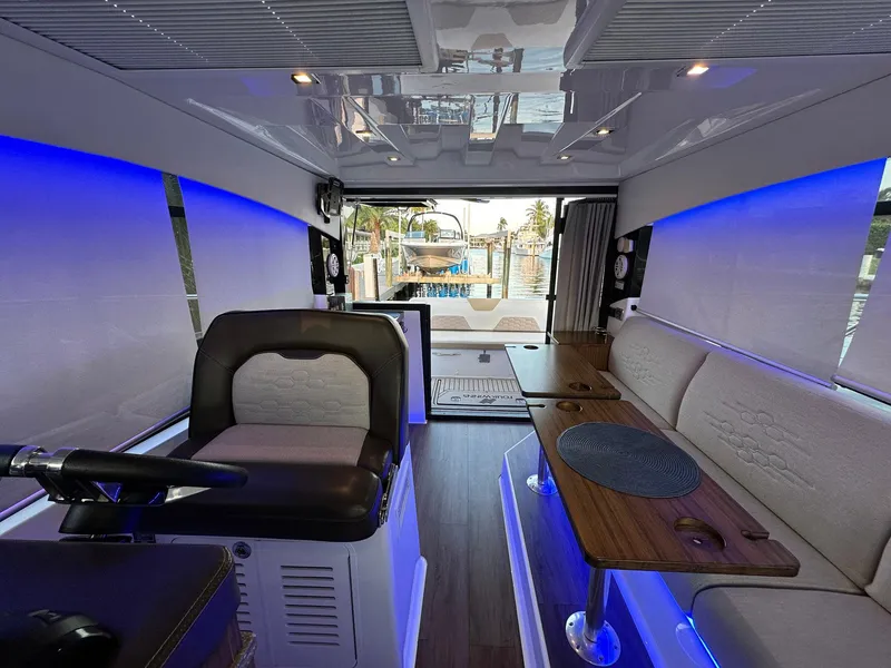 Slide: The Image of Interior of 2020 Four Winns Vista 355 Coupe with modern seating and ambient blue lighting. - 19