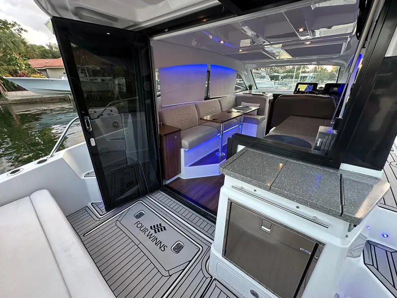 Slide: The Image of 2020 Four Winns Vista 355 Coupe interior with modern seating and ambient lighting. - 22