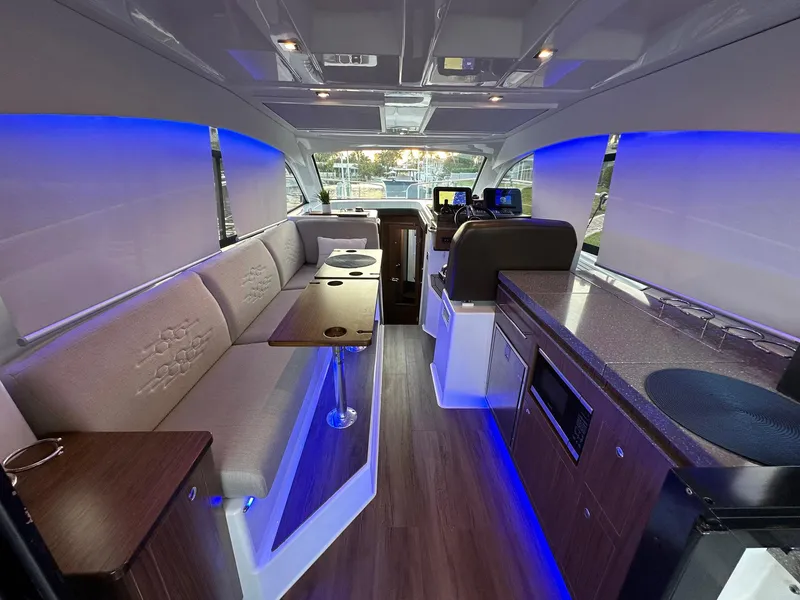 Slide: The Image of 2020 Four Winns Vista 355 Coupe interior with modern seating, ambient lighting, and sleek design. - 24