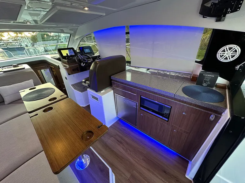 Slide: The Image of Interior of 2020 Four Winns Vista 355 Coupe with modern kitchen and seating area. - 25