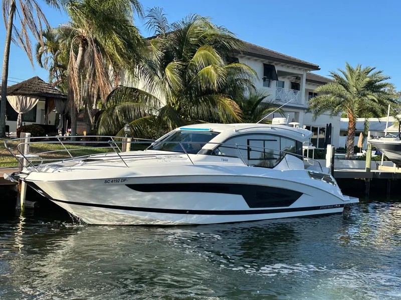 Slide: The Image of 2020 Four Winns Vista 355 Coupe docked by palm trees and waterfront home. - 35