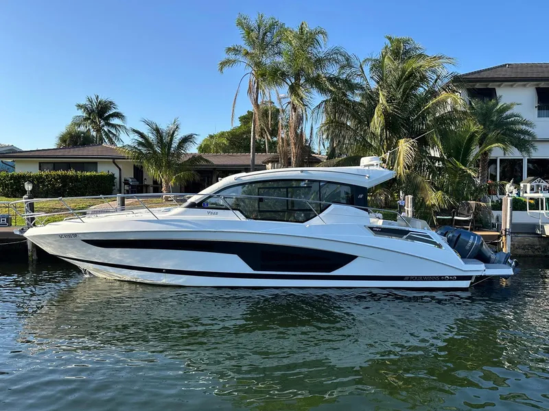 Slide: The Image of 2020 Four Winns Vista 355 Coupe docked by palm trees and waterfront homes. - 36