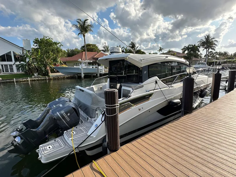 Slide: The Image of 2020 Four Winns Vista 355 Coupe docked by a waterfront home under a partly cloudy sky. - 4