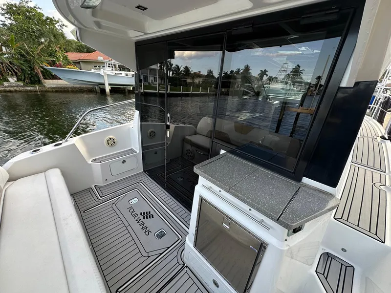 Slide: The Image of 2020 Four Winns Vista 355 Coupe boat deck with seating and waterfront view. - 5