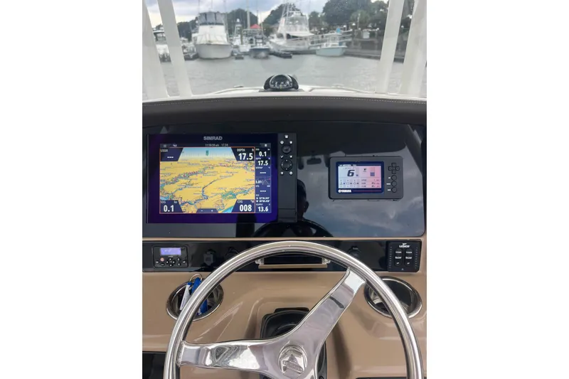 Slide: The Image of Boat dashboard with navigation screens, steering wheel, and controls on a 2021 Robolo 242EX. - 13