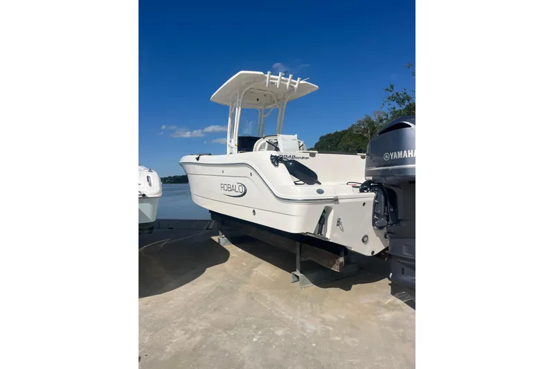 Slide: The Image of 2021 Robolo 242EX boat with Yamaha engine, docked under clear blue sky. - 2