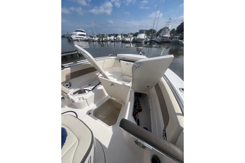 Slide: The Image of Open storage compartments on a 2021 Robolo 242EX boat docked at a marina. - 5