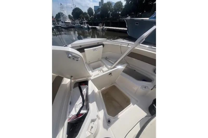 Slide: The Image of Open storage compartments on a 2021 Robolo 242EX boat docked at a marina. - 6