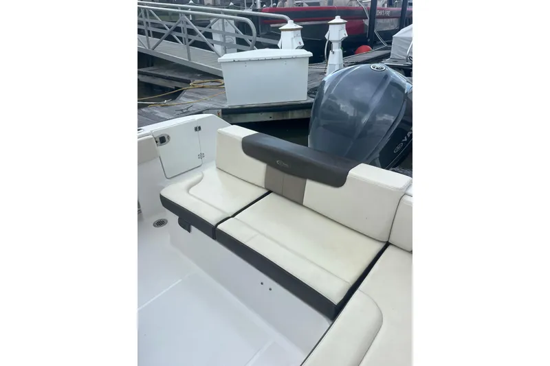 Slide: The Image of 2021 Robolo 242EX boat with cushioned seating and outboard motor at dock. - 8