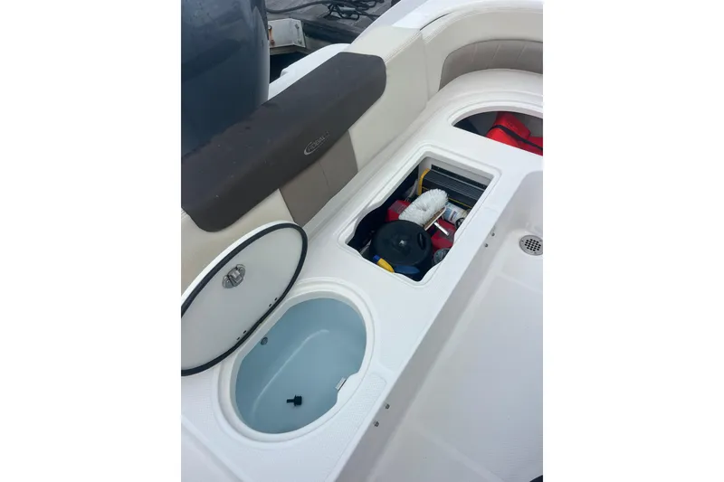 Slide: The Image of 2021 Robolo 242EX boat storage compartments with open hatches and cleaning supplies. - 9