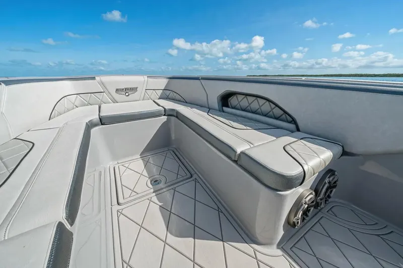 Slide: The Image of Luxury seating on 2025 Deep Impact 369 Sport boat under clear blue sky. - 16