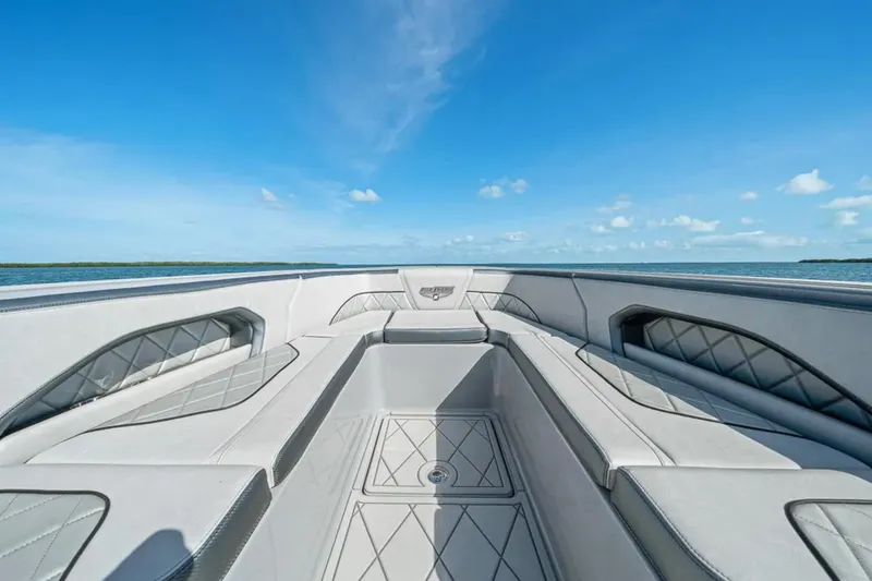 Slide: The Image of 2025 Deep Impact 369 Sport boat interior with luxurious seating, ocean view, and clear blue sky. - 17