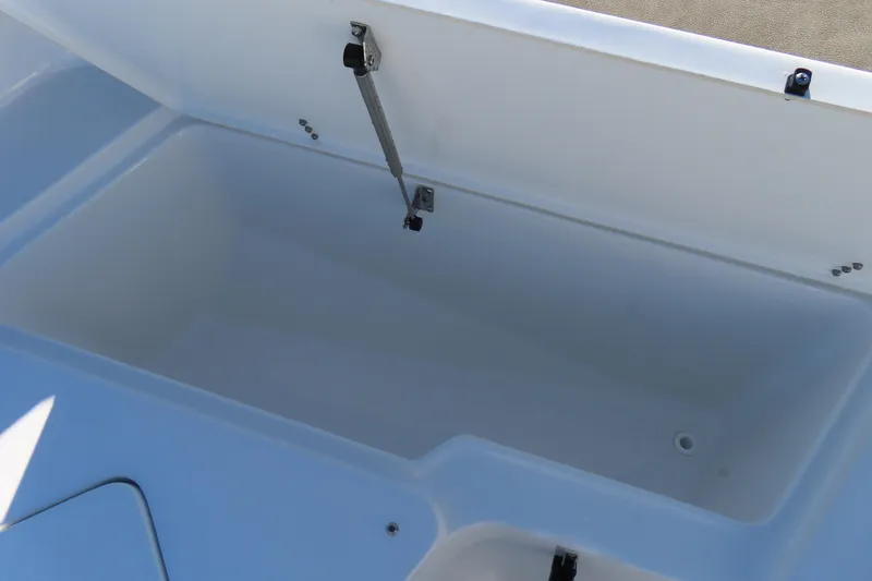 Slide: The Image of 2025 Sea Hunt Ultra 245 SE storage compartment, open lid, spacious interior. - 11