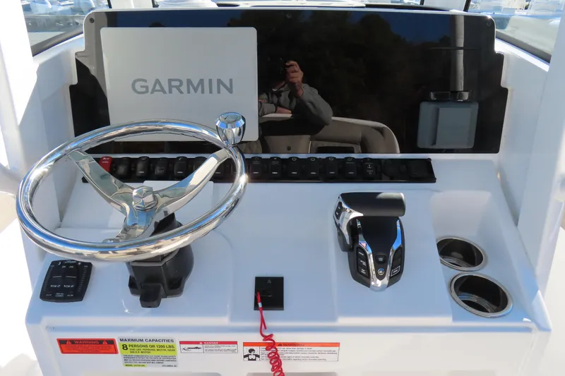 Slide: The Image of 2025 Sea Hunt Ultra 245 SE boat dashboard with Garmin display and controls. - 23