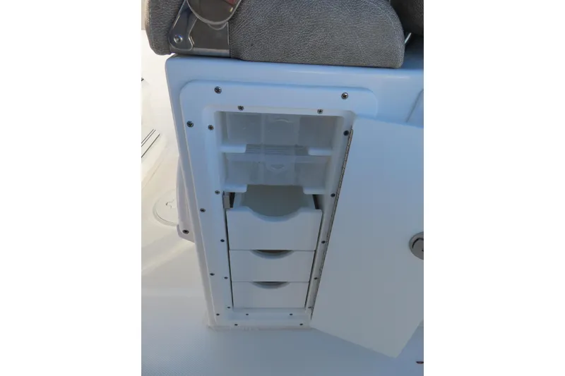 Slide: The Image of 2025 Sea Hunt Ultra 245 SE boat storage compartment with open drawers. - 30
