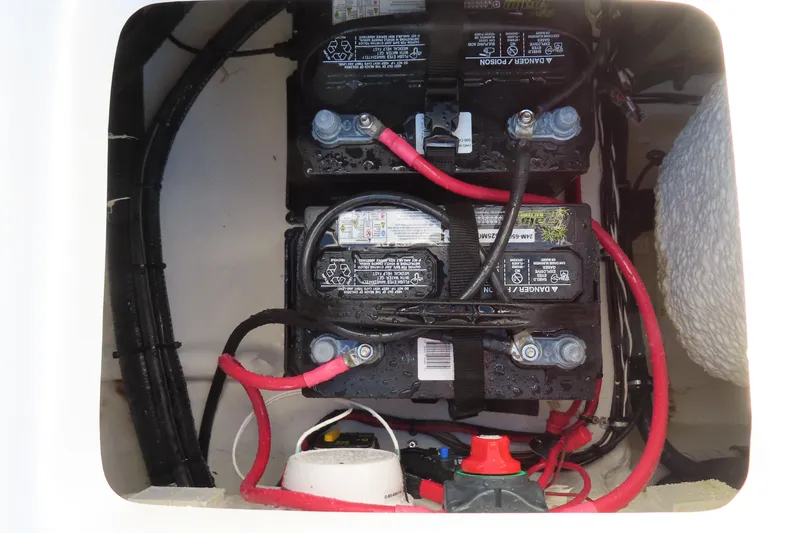 Slide: The Image of Battery compartment of 2025 Sea Hunt Ultra 245 SE boat with wiring and connections. - 38